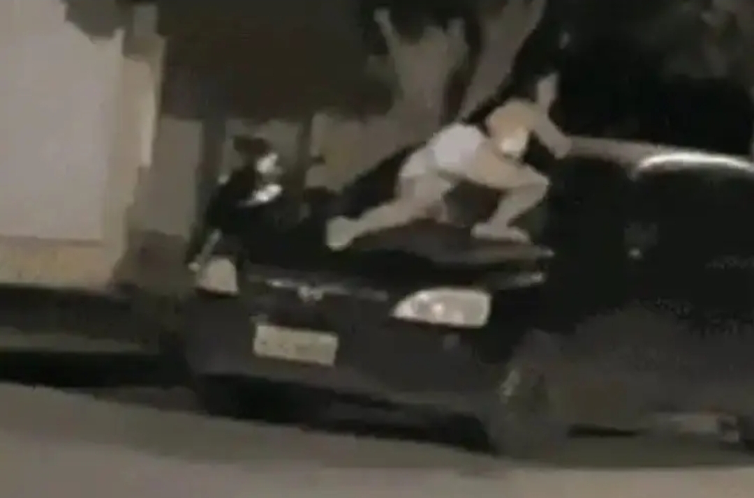 Mulher se pendura em para-brisa de carro para impedir marido de levar filha